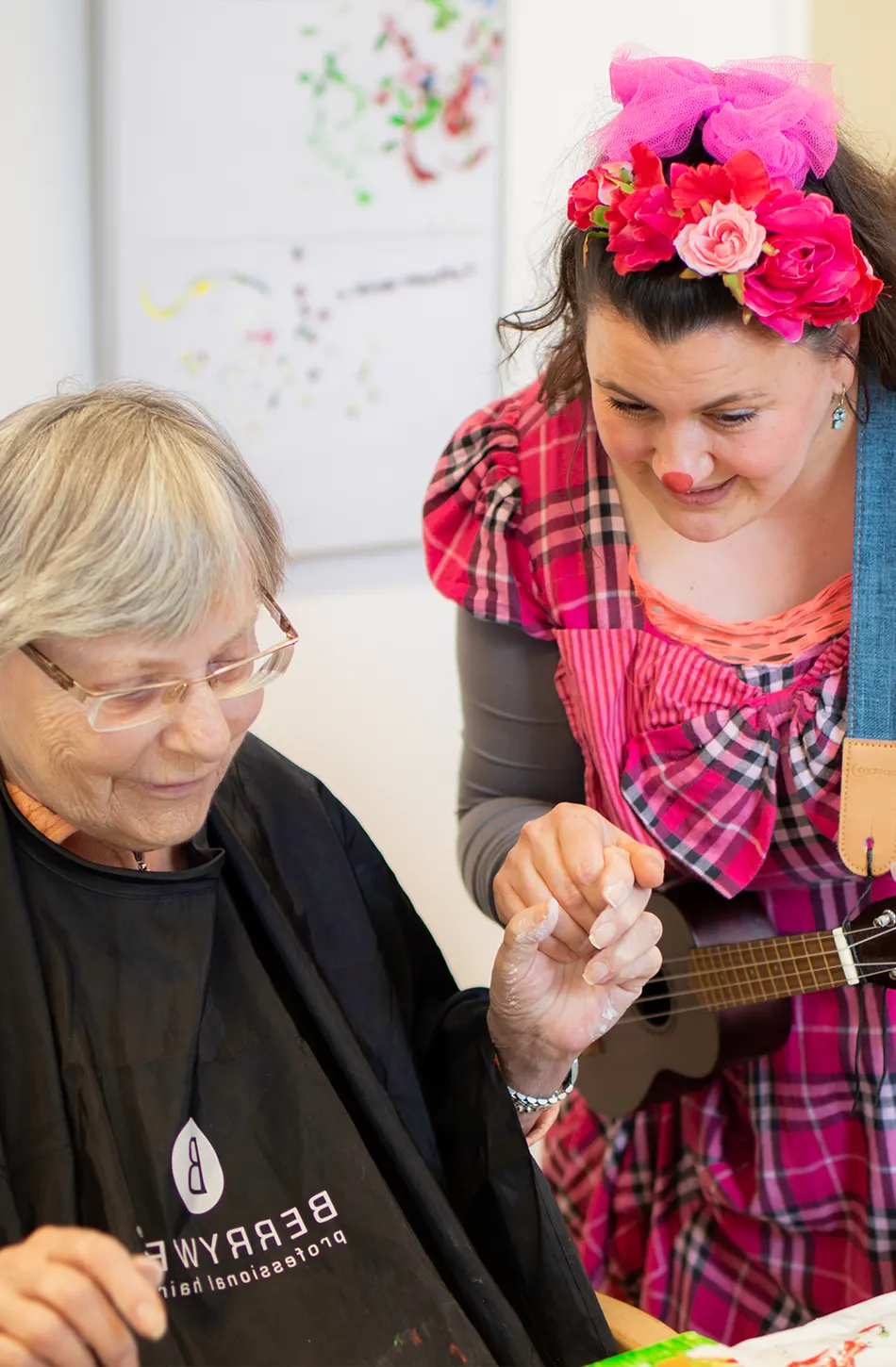 Clownin Tiffi zaubert einer Seniorin mit liebevoller Nähe im Seniorenheim ein Lächeln ins Gesicht